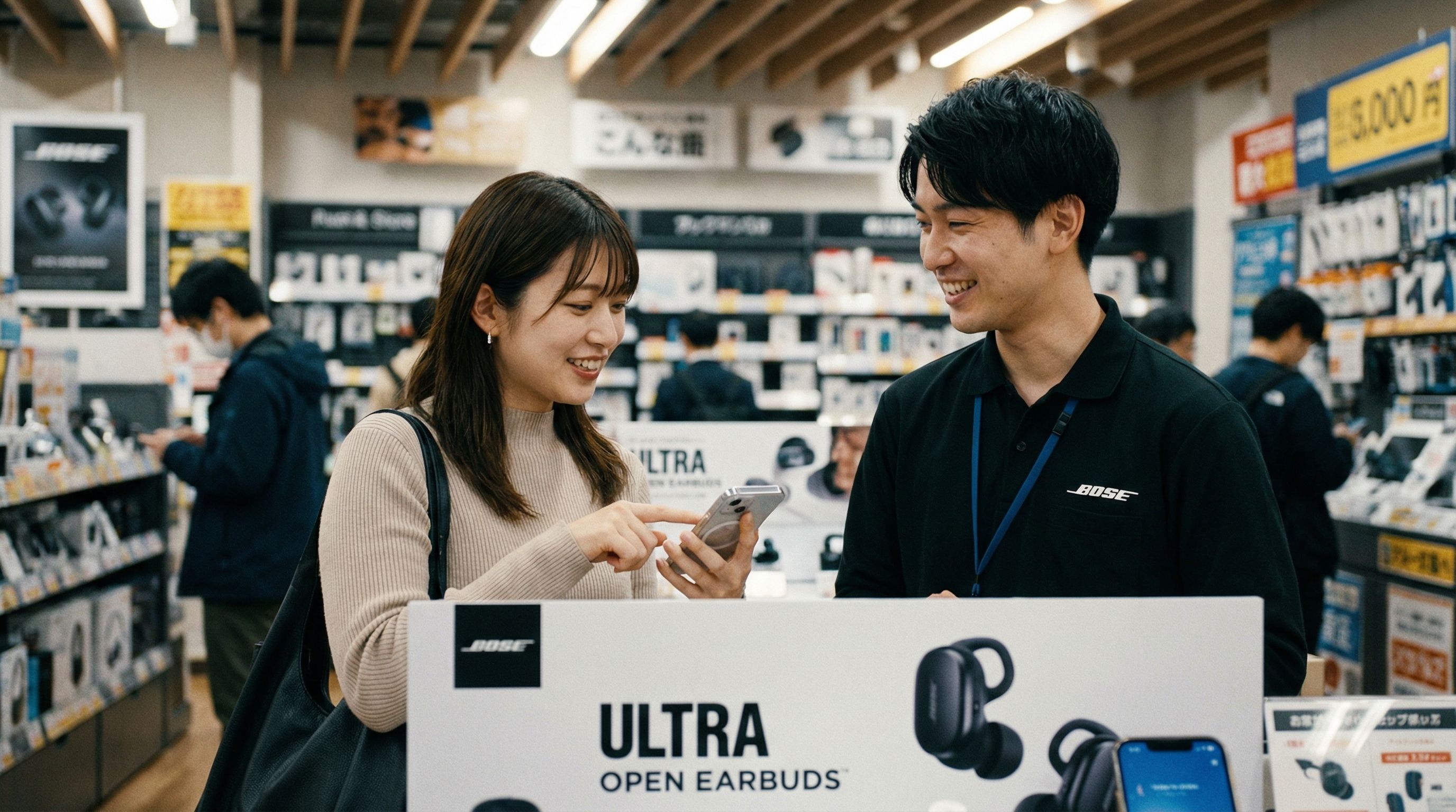家電量販店でBose Ultra Open Earbudsの価格について相談する女性

